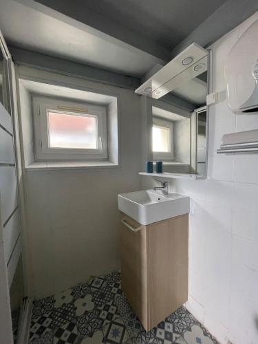 une petite salle de bain avec un lavabo et une fenêtre dans l'établissement Petit studio du Palais, à Les Sables-dʼOlonne