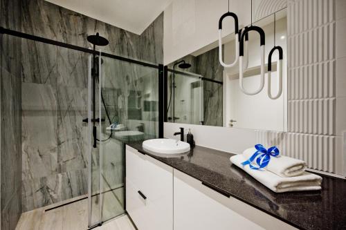 a bathroom with a glass shower and a sink at Hotel LIDO in Jurata