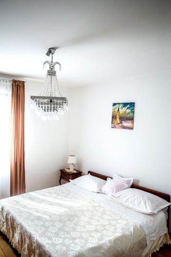 a bedroom with a white bed and a chandelier at Split Apartments Shell in Split