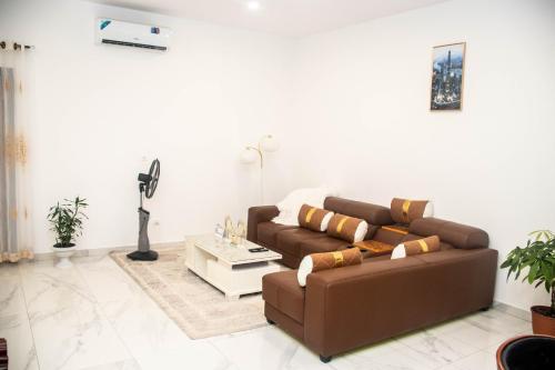 a living room with a brown couch and a table at Gabon Happiness House in Libreville
