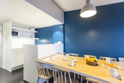 une salle à manger avec une table en bois et un mur bleu dans l'établissement Résidence Thuria - 3 Pièces pour 8 Personnes MAE-2184, à Arc 1800