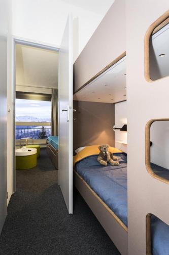 - une chambre avec un lit superposé avec un ours en peluche dans l'établissement Résidence Thuria - 3 Pièces pour 8 Personnes MAE-2184, à Arc 1800