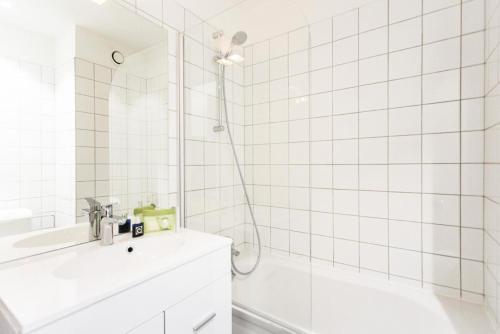 La salle de bains est pourvue de carrelage blanc, d'un lavabo et d'une douche. dans l'établissement Résidence Thuria - 3 Pièces pour 8 Personnes MAE-2184, à Arc 1800