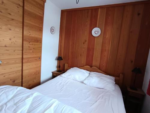 - une chambre avec un lit blanc et des murs en bois dans l'établissement Chalet Du Bois De Suffin N 8 - Appartement cosy à 50m des pistes ! Plein sud - Terrasse - garage MAE-8664, à Montgenèvre