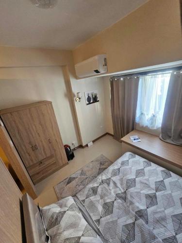 a small bedroom with a bed and a window at SMDC Field REsidences condo unit in Manila