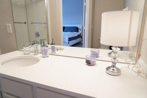 a bathroom sink with a lamp and a mirror at New Luxury Townhome near Disney in Orlando