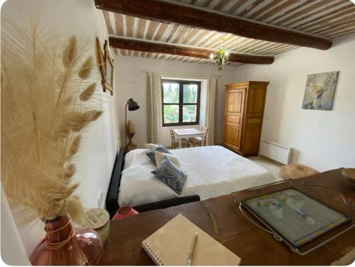 - une chambre avec un lit et une table en bois avec un sidx dans l'établissement Studio Mas de Papé Verquieres Saint Rémy de Provence, à Verquières
