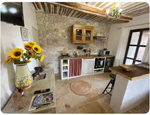 une cuisine avec un vase de tournesols sur une table dans l'établissement Studio Mas de Papé Verquieres Saint Rémy de Provence, à Verquières