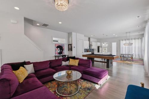 a living room with a purple couch and a table at PoolTable-15 Mins to Uptown & DT-King Bed! in Charlotte