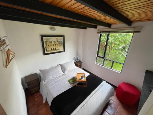 a bedroom with a bed and a window at EL REFUGIO Cabaña Campestre in Sogamoso