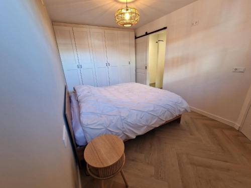 a small bedroom with a bed and a table at De oude brouwerij in Reusel