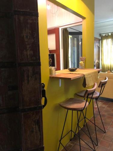 une cuisine avec un comptoir et des tabourets dans une pièce dans l'établissement Studio au milieu des vignes, à Tresques