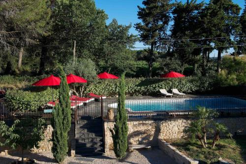 - une piscine avec des parasols et des chaises rouges dans l'établissement Studio au milieu des vignes, à Tresques