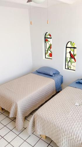 two beds in a room with stained glass windows at Gardenia Roof Hostel in Aguascalientes