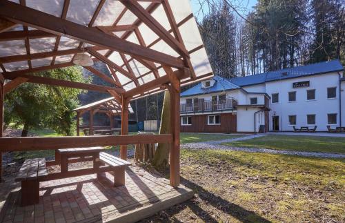 a wooden pavilion in front of a white building at Penzión MALINO in Ružomberok