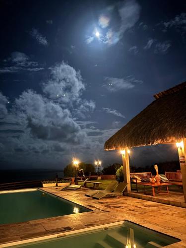 a night view of a swimming pool at a resort at Lyttos Bungalows in Icapuí