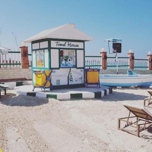 a small kiosk on the beach with two chairs at Riviera Beach Chalets in Marsa Matruh