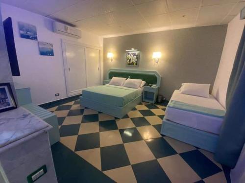 a room with two beds and a checkered floor at Riviera Beach Chalets in Marsa Matruh