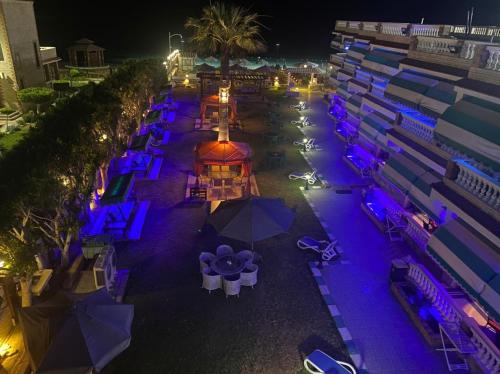 an aerial view of a beach with tables and umbrellas at night at Riviera Beach Chalets in Marsa Matruh