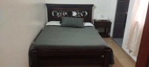 a bedroom with a large bed with a wooden headboard at Hotel Esmeralda Duitama in Duitama