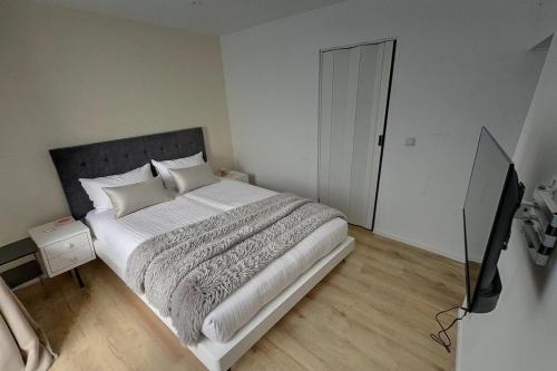 a bedroom with a large bed and a television at Jean 1B Brussels-Charleroi-Airport in Charleroi