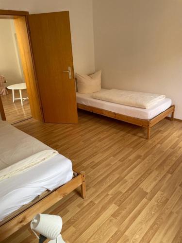a room with two beds and a wooden floor at Drei Linden Stadtmarkt in Wolfenbüttel