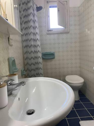 a bathroom with a white sink and a toilet at House with Garden 30 meters from the Sea in Torre Squillace