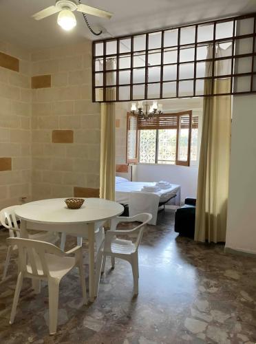 a dining room with a white table and chairs at House with Garden 30 meters from the Sea in Torre Squillace
