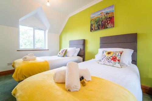 2 Betten in einem Zimmer mit gelben und grünen Wänden in der Unterkunft Morea Cottage - 2 Bed - Hot tub in Horning