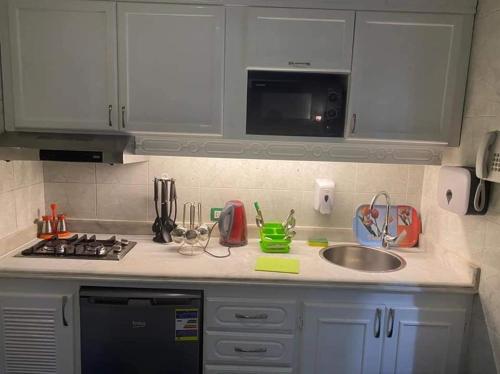 a kitchen counter with a sink and a microwave at Riviera Beach Chalets in Marsa Matruh