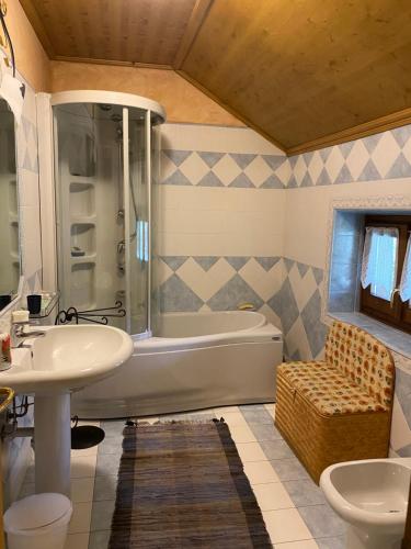 ein Badezimmer mit Badewanne, Waschbecken und Dusche in der Unterkunft Villa Avio in Temù