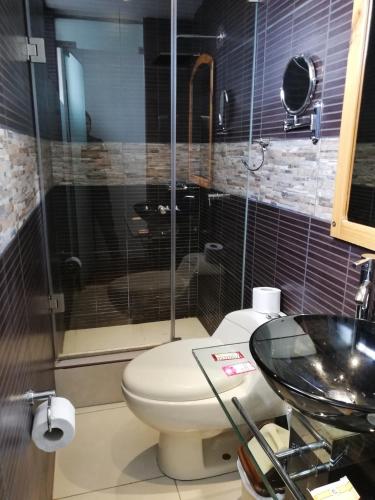 a bathroom with a toilet and a glass shower at Terra Fecundis in Arequipa