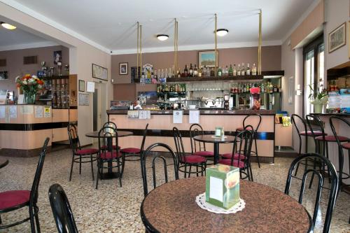 a restaurant with tables and chairs and a bar at Hotel Olimpia in Sirmione