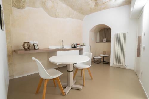 a kitchen with a table and two white chairs at Al Vico Affittacamere in Matera