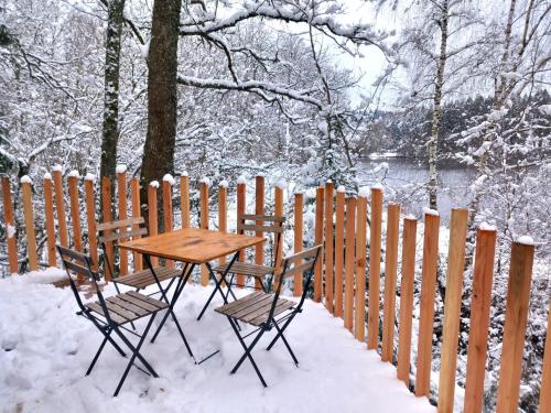 a table and chairs in the snow next to a fence at Domaine du Balbuzard in Condat-en-Combraille
