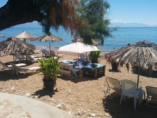 a beach with chairs and umbrellas and the ocean at Apartments Katoji in Chrani