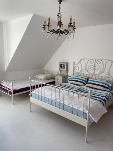 a white bedroom with a bed and a chandelier at Willa Róż Wisełka in Wisełka