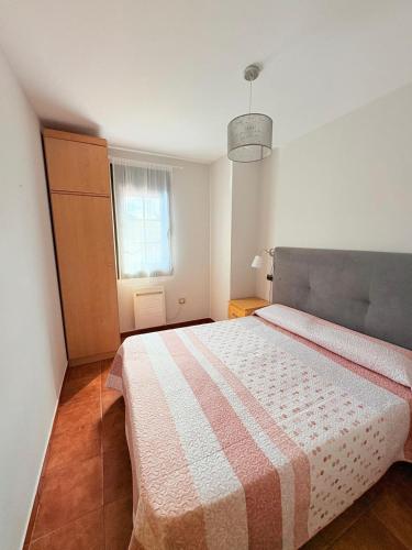a bedroom with a bed with a blanket on it at Apartamentos Luarca in Luarca