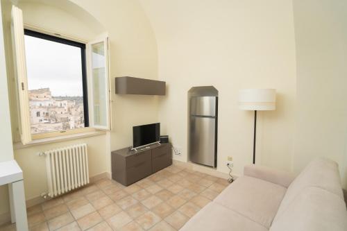 a living room with a couch and a television at Al Vico Affittacamere in Matera