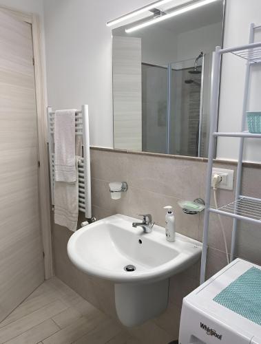 ein weißes Badezimmer mit Waschbecken und Spiegel in der Unterkunft Serenità Tropea in Tropea