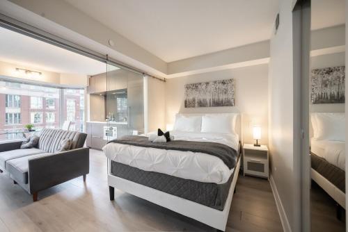 a bedroom with a large bed and a chair at Discounted Elegant Yorkville Suite in Toronto
