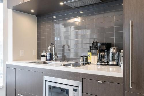 a kitchen with a sink and a counter at Discounted Elegant Yorkville Suite in Toronto