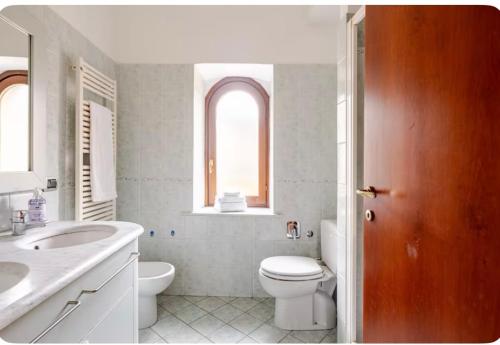 a white bathroom with a toilet and a sink at Levanto Charme apartment up to 6ppl 20 steps to the water in the center in Levanto