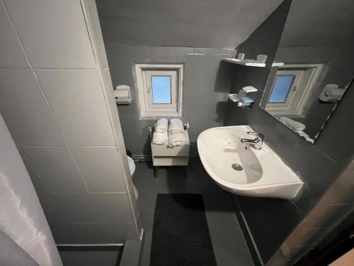 a small bathroom with a sink and a mirror at Vila Valentina in Buşteni