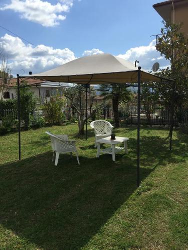 a tent with a table and two chairs under it at A casa di mamma in Rieti
