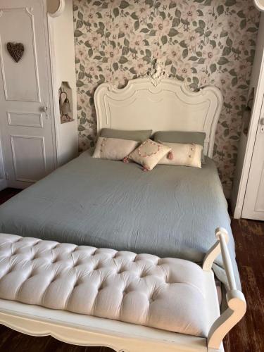 サン・シプリアンにあるLa périgourdine et son spaの花柄の壁紙を用いたベッドルームの白いベッド1台