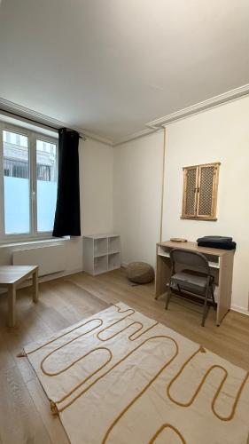 Cette chambre dispose d'un bureau et d'un tapis. dans l'établissement Limare - Studio Hypercentre Orléans, à Orléans