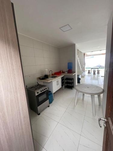 a kitchen with a stove and a table in it at Barra de Jacuipe beach house in Barra de Jacuípe