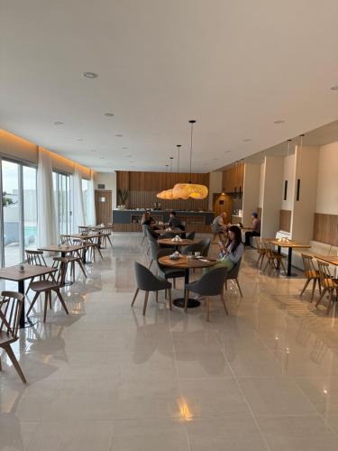 a restaurant with tables and chairs and people sitting at tables at Urban Suites Oliva in Oliva