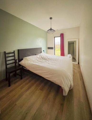 une chambre avec un lit et un parquet dans l'établissement Maison d'architecte à Semblançay, à Semblançay